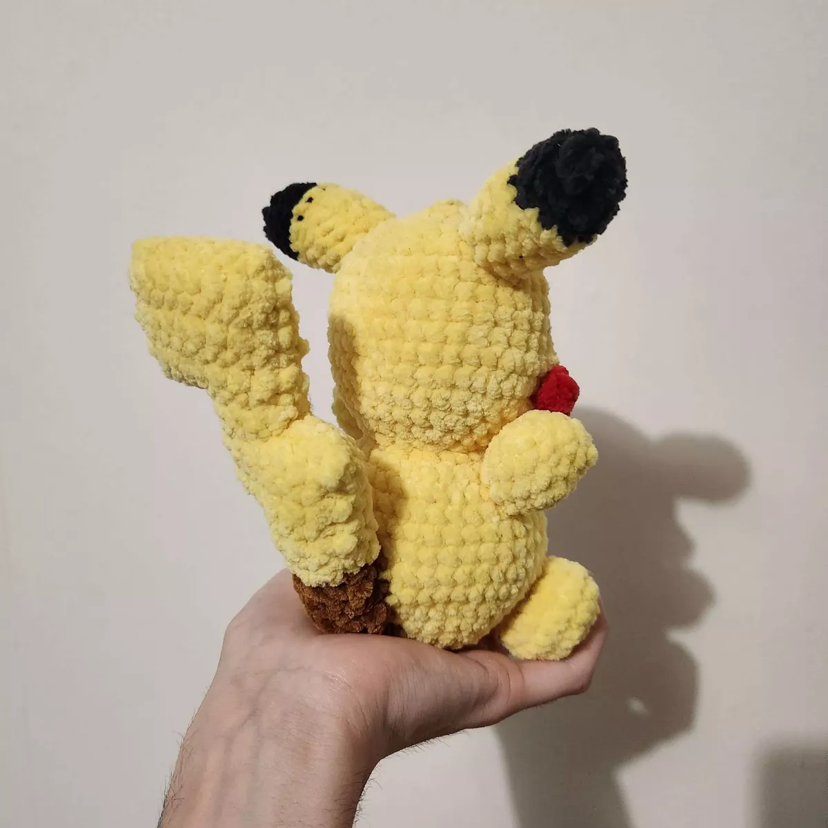 Pikachu crochet - vue latérale montrant la queue et les finitions brodées - création faite main